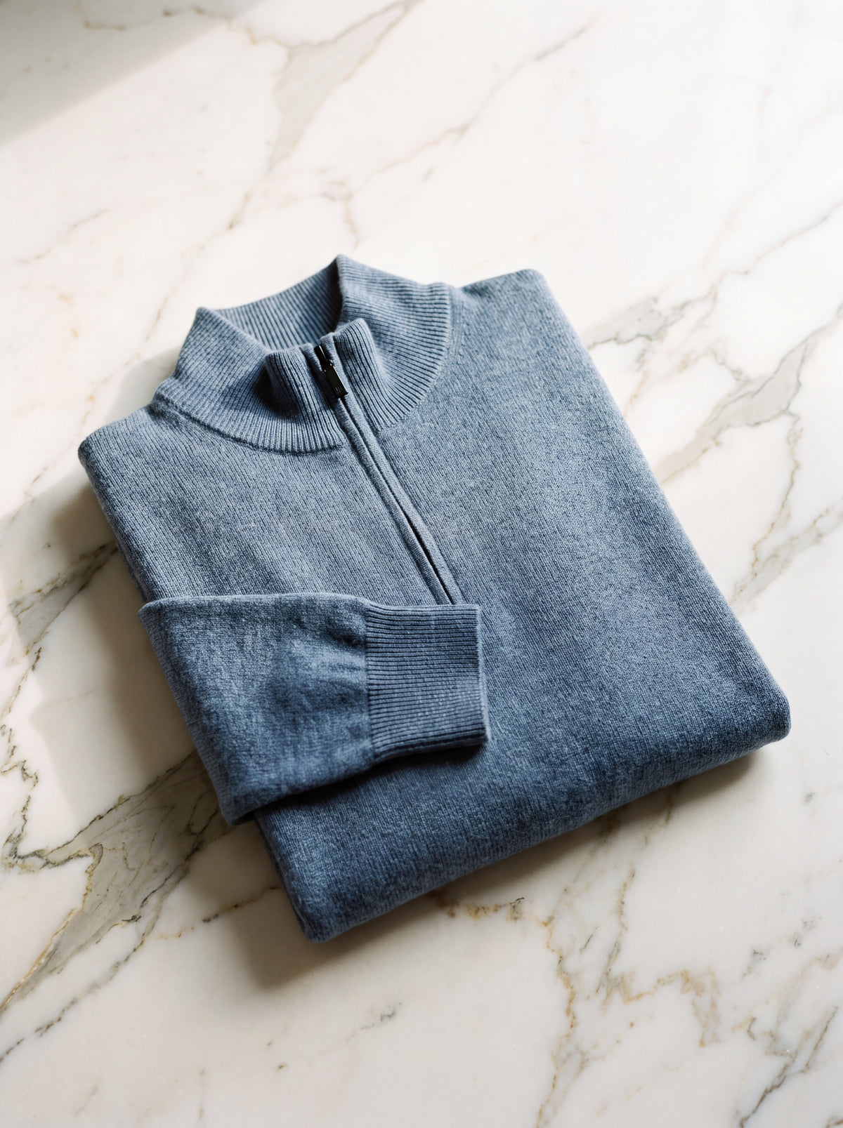 Francesco Bellani Como quarter-zip folded on pale marble with the collar standing and zip pull visible