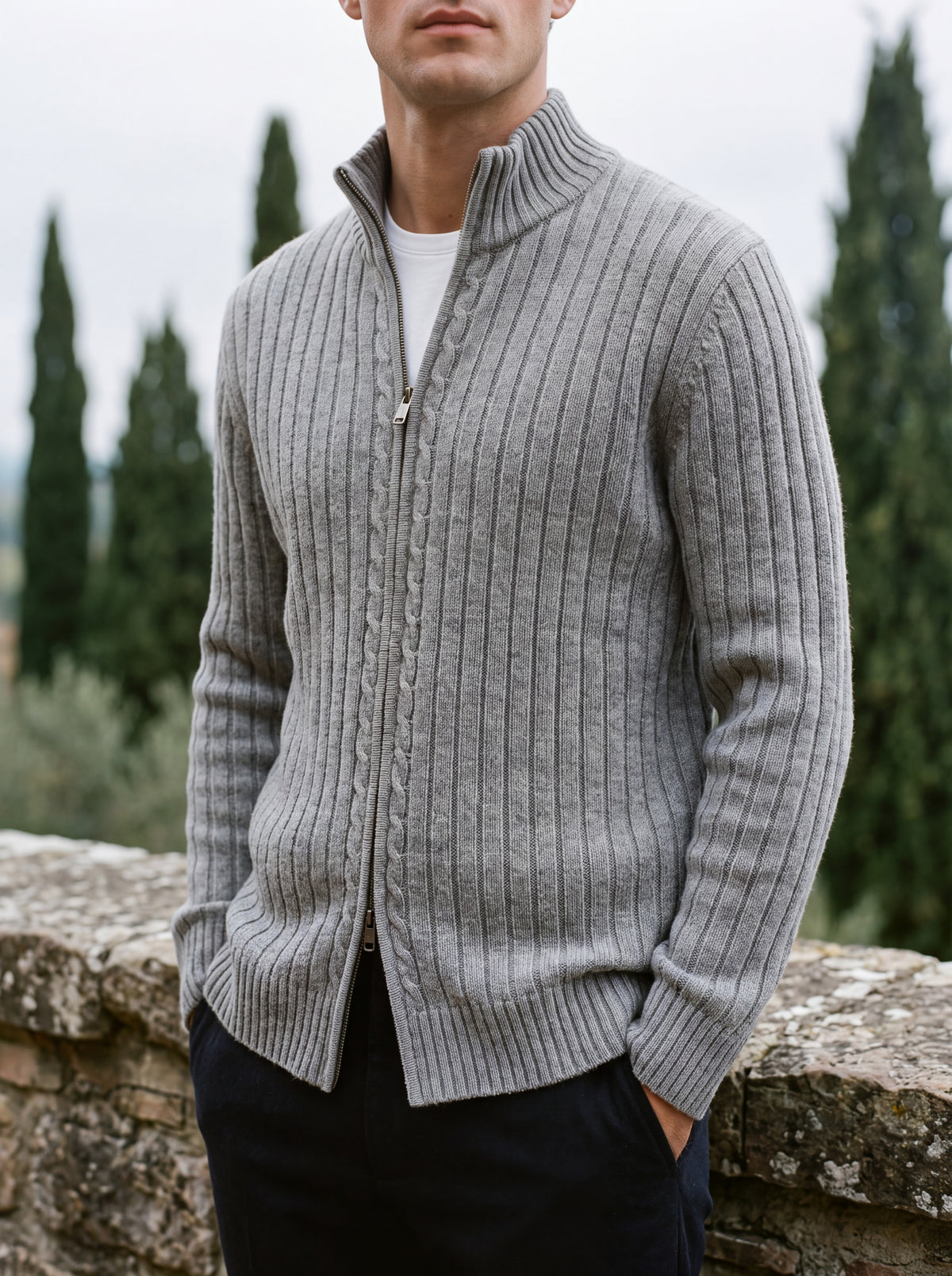 Francesco Bellani Aosta cable-knit wool zip-through worn half-zipped on a stone terrace with cypress behind