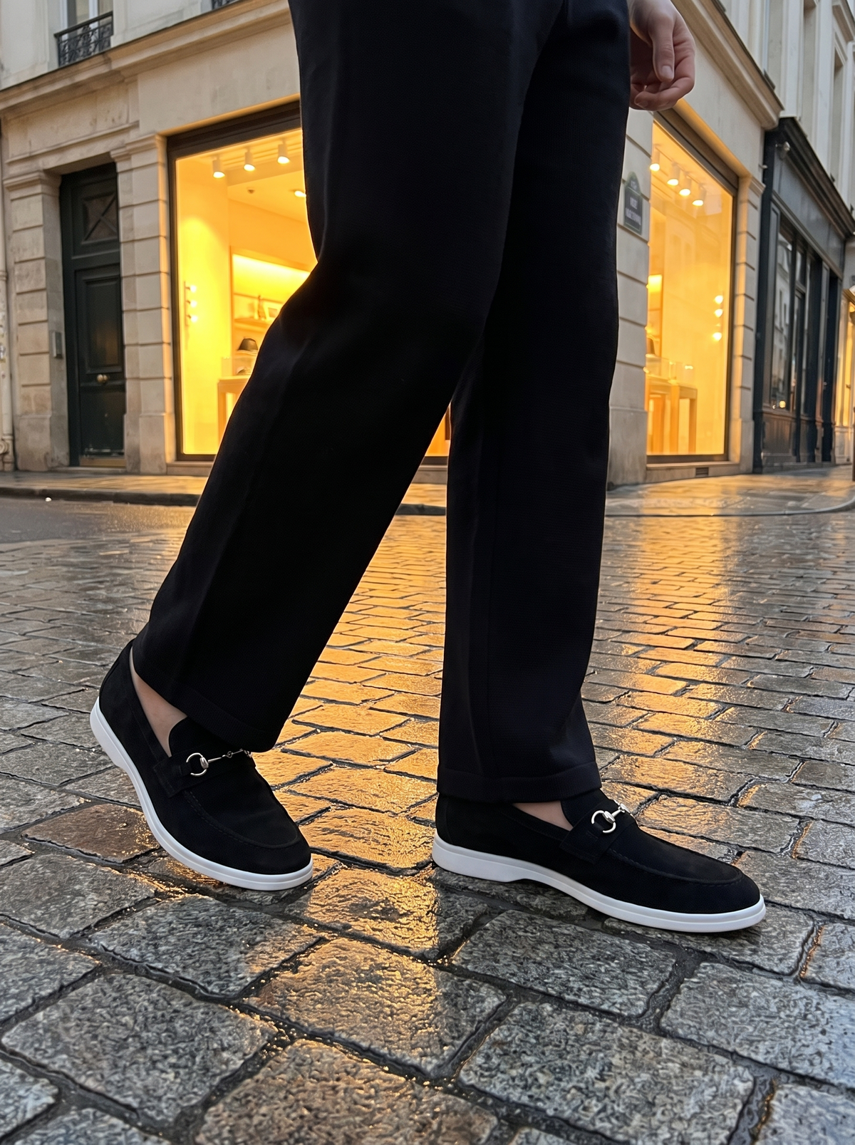 Cernobbio loafer in black suede on wet cobbles at dusk