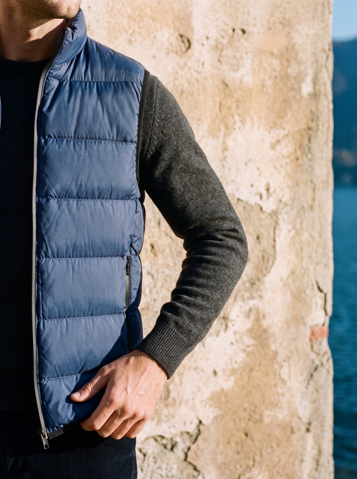 Francesco Bellani Lombardia quilted gilet worn over a fine knit against a weathered stucco wall