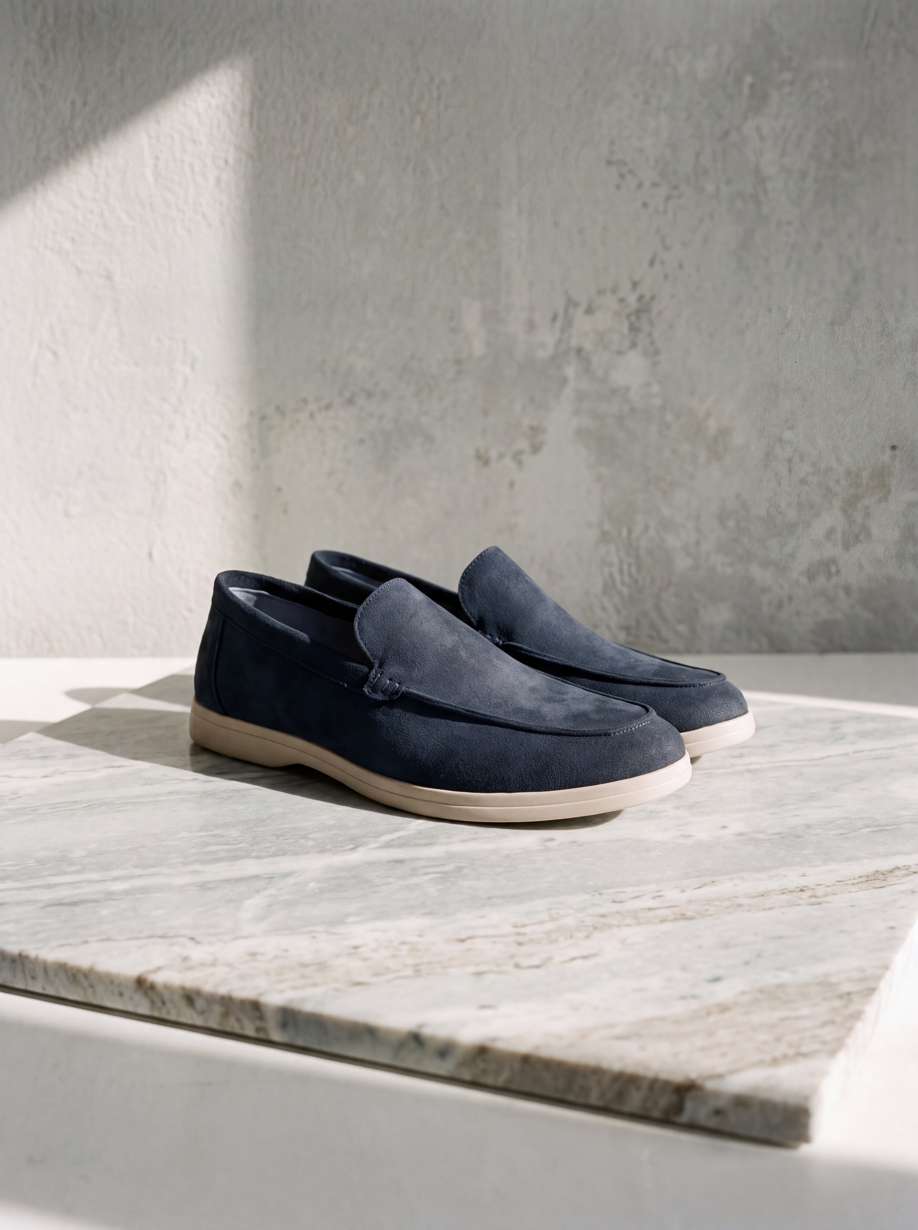 Francesco Bellani Bellagio loafers in leather, photographed as a pair on pale veined marble against a weathered stucco wall