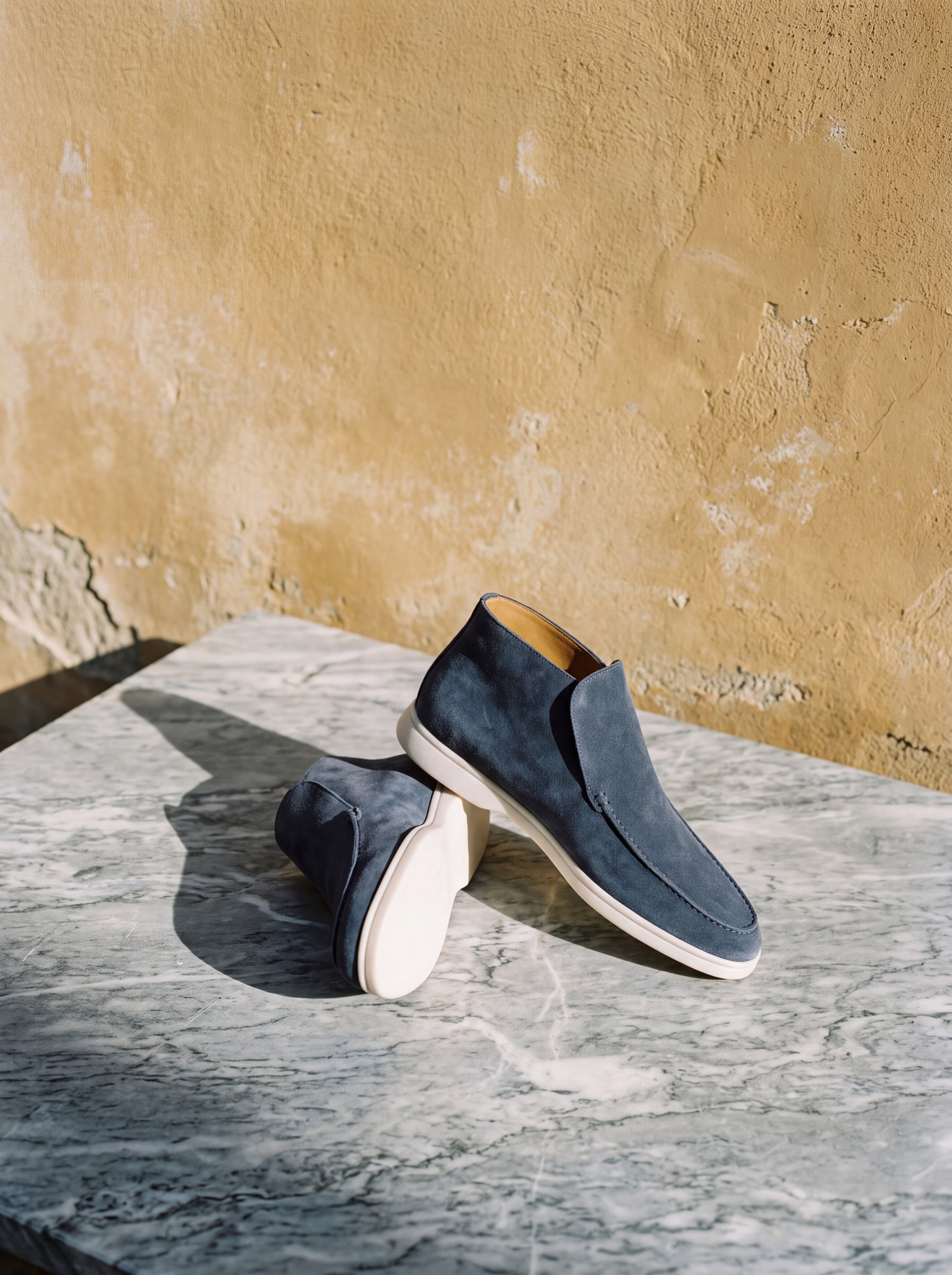 Francesco Bellani Varenna high loafers on grey veined marble against weathered ochre plaster
