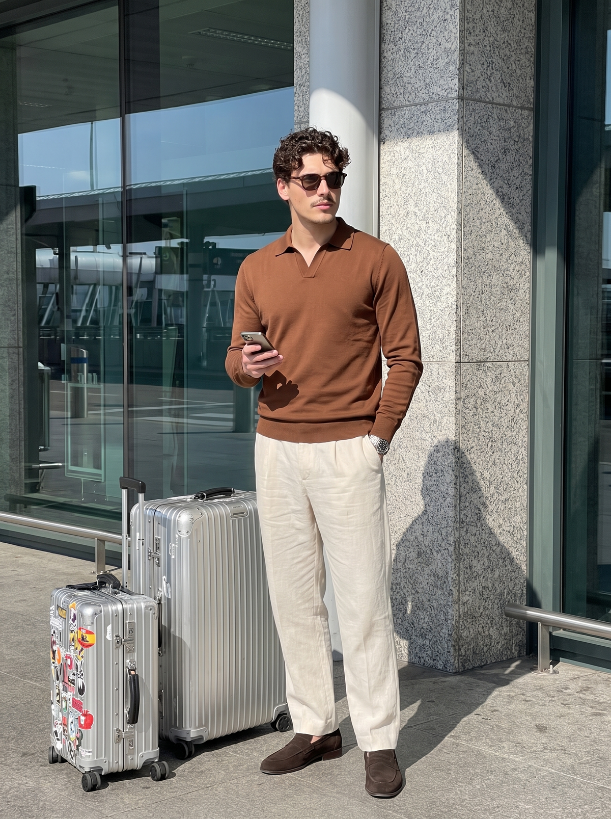 Man wearing a cinnamon brown knitted polo on an airport forecourt — Francesco Bellani Solferino