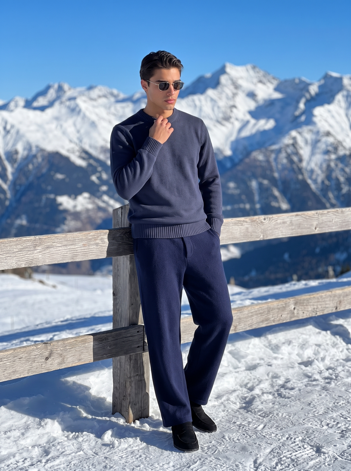 Man wearing a navy blue wool pullover against a fence in alpine snow — Francesco Bellani Navigli