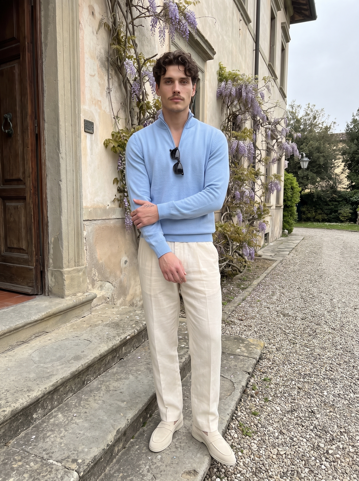Man wearing a light blue wool quarter-zip on the stone steps of a villa doorway — Francesco Bellani Como