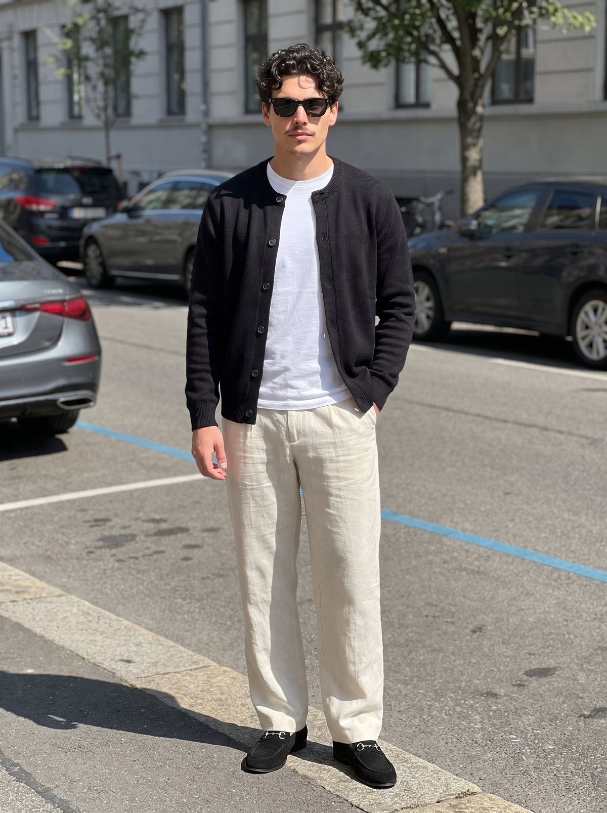 Asolo knit cardigan in Midnight Black, worn open over a white tee at a kerbside